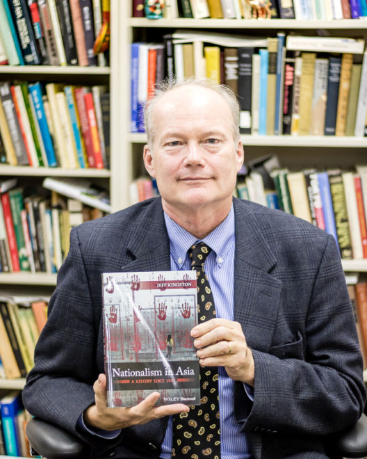 Professor Kingston holding one of his latest books
