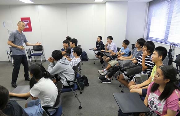 Junior high school students sit at desks in a classroom