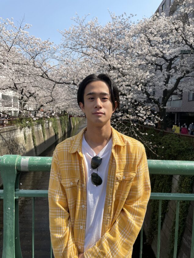 Riku Sakae, on his way to campus, in front of cherry blossom